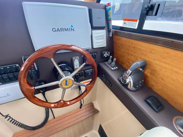  Yacht Photos Pics 2015 Cutwater C-28 helm with Garmin navigation, wooden steering wheel, and control panel.