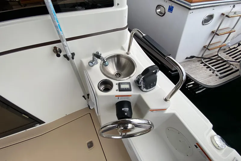  Yacht Photos Pics 2015 Cutwater C-28 boat helm with steering wheel, sink, and controls.