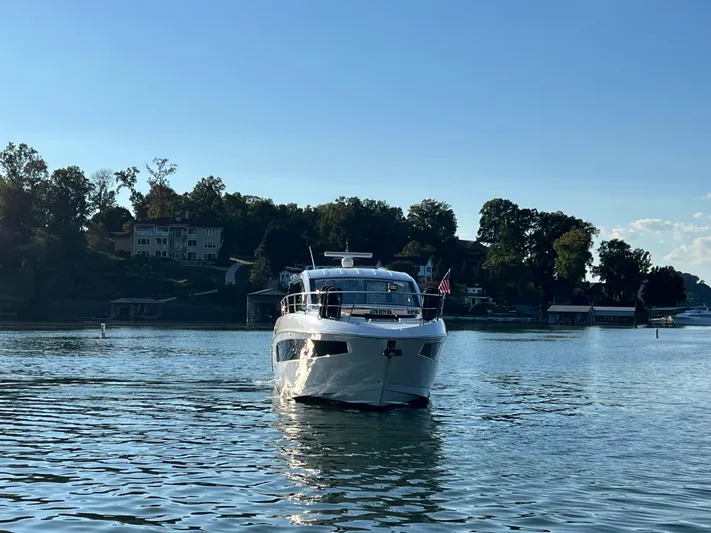 Southern Comfort Yacht Photos Pics 2022 Cruisers Yachts 390 Express Coupe on a serene lake with scenic background.