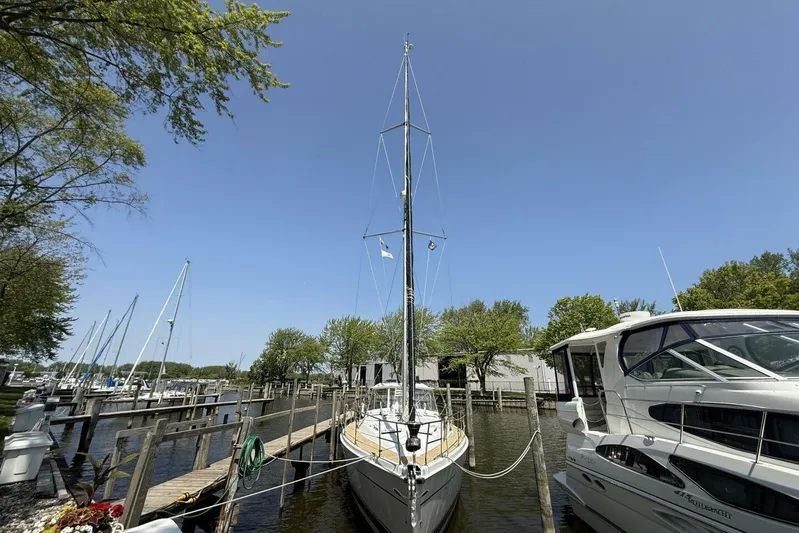  Yacht Photos Pics Sailboat docked at marina, Hunter 46LE 2005, surrounded by trees and clear blue sky.