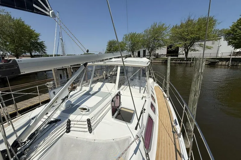  Yacht Photos Pics Sailboat docked at marina, Hunter 46LE 2005 model, sunny day, trees in background.