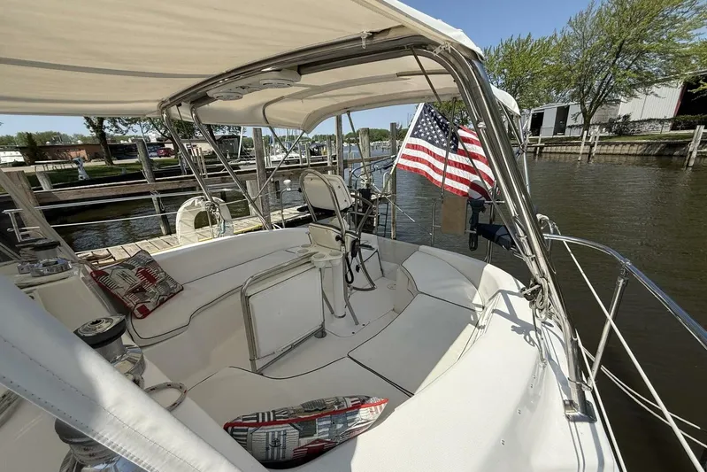  Yacht Photos Pics Sailboat cockpit with American flag, Hunter 46LE, 2005 model, docked by a calm river.