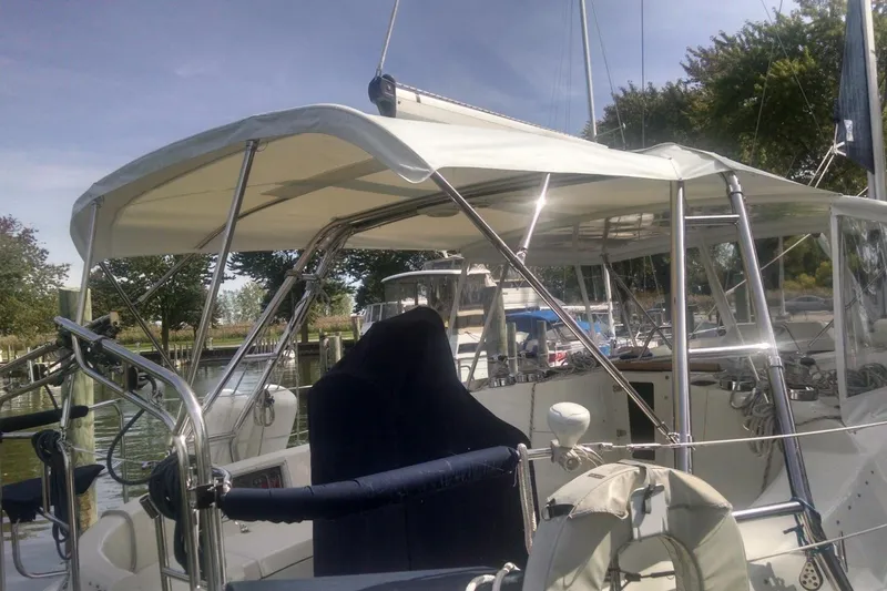  Yacht Photos Pics 2005 Hunter 46LE sailboat cockpit with canopy, docked in a marina.