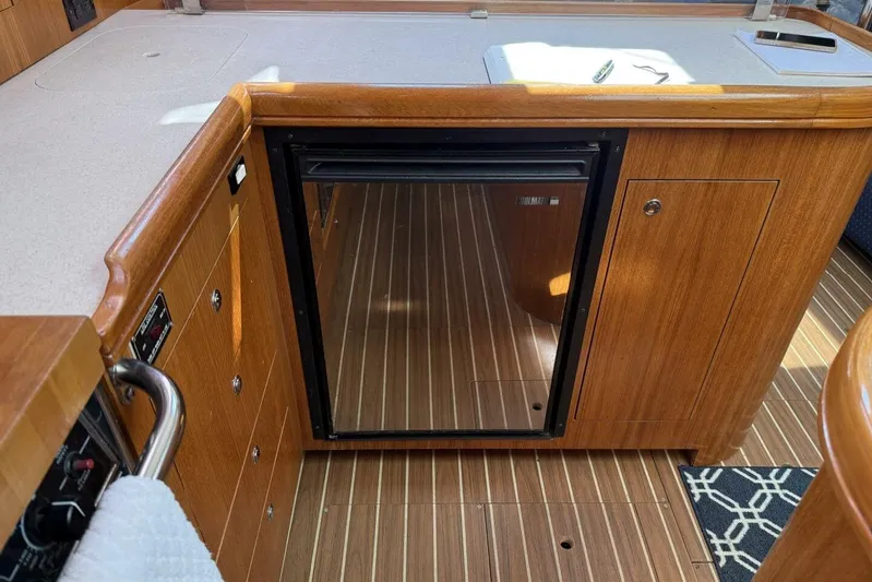  Yacht Photos Pics 2005 Hunter 46LE yacht interior with wooden cabinetry and mini fridge.