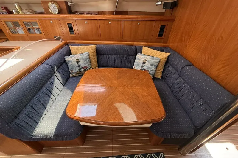  Yacht Photos Pics Cozy dining area in 2005 Hunter 46LE yacht with blue cushions and wooden table.