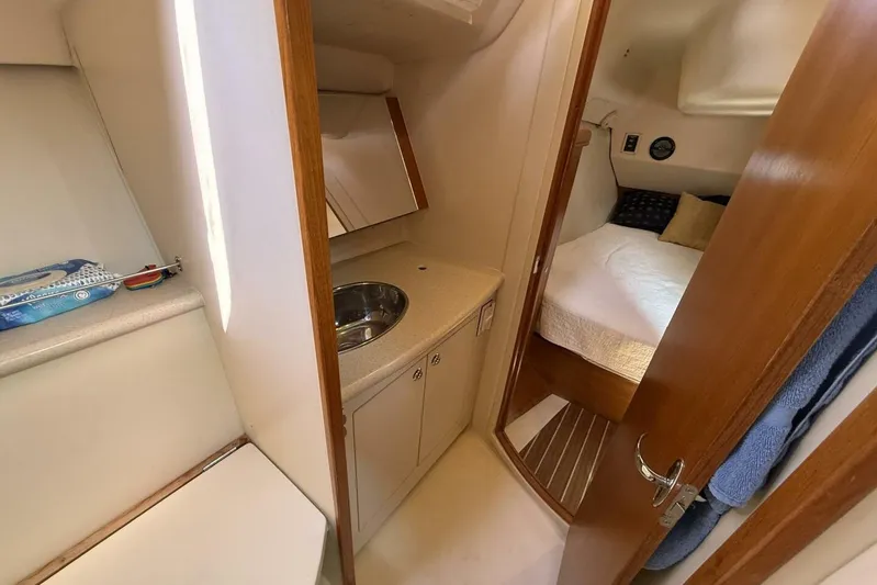  Yacht Photos Pics 2005 Hunter 46LE yacht interior with compact bathroom and cozy bedroom.