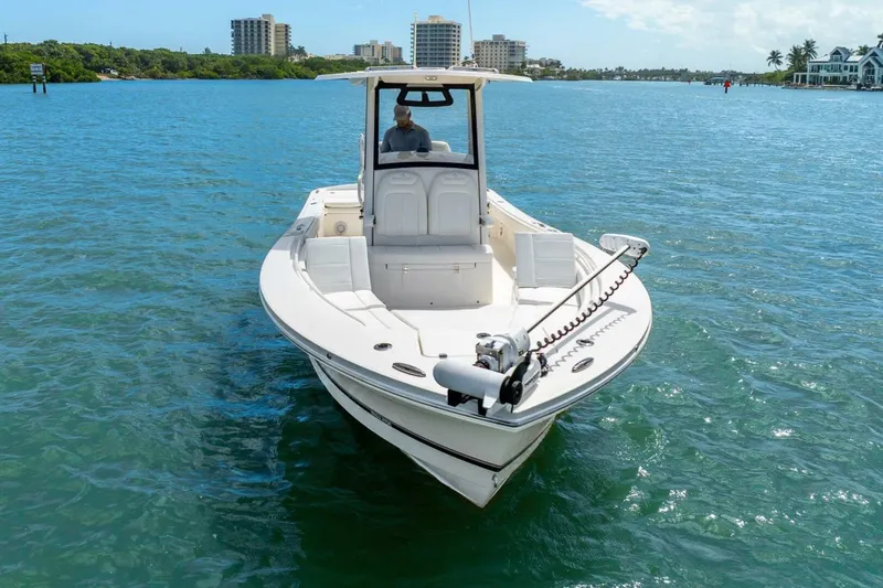 Yacht Photos Pics 2021 Regulator 26XO boat on clear blue water with cityscape background.