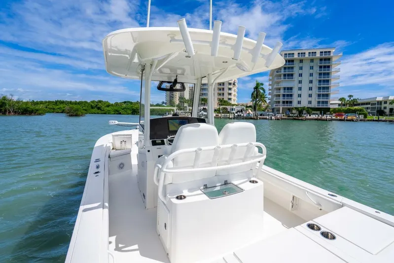  Yacht Photos Pics 2021 Regulator 26XO boat on water, with modern console and seating, near waterfront buildings.