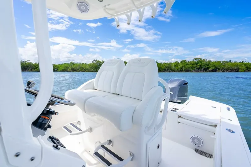  Yacht Photos Pics 2021 Regulator 26XO boat interior with white seating, steering console, and scenic water view.