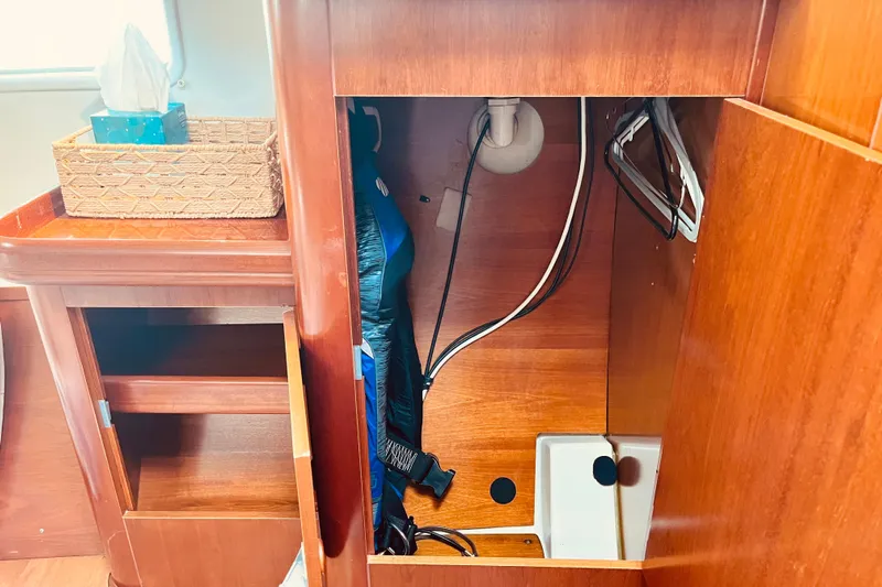 Windnsea Yacht Photos Pics Interior view of a 2001 Beneteau 473 sailboat, showcasing wooden cabinetry and storage space.