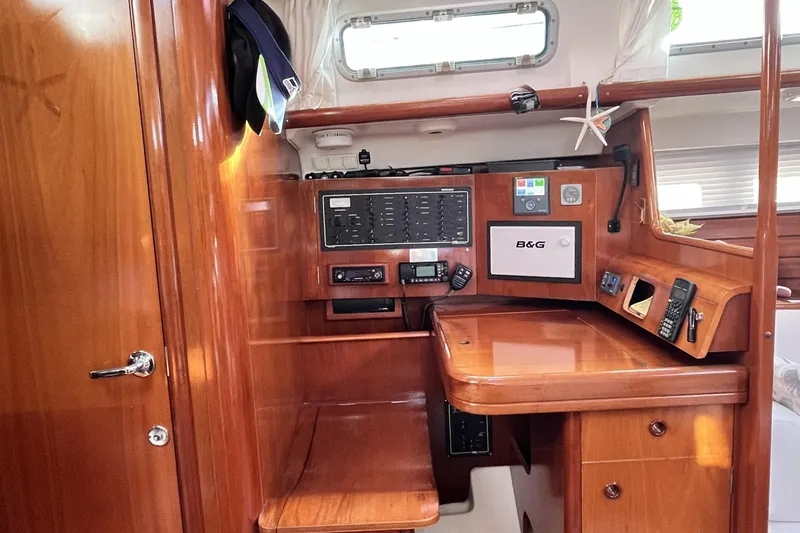 Windnsea Yacht Photos Pics Interior of 2001 Beneteau 473 sailboat with navigation equipment and wooden finish.
