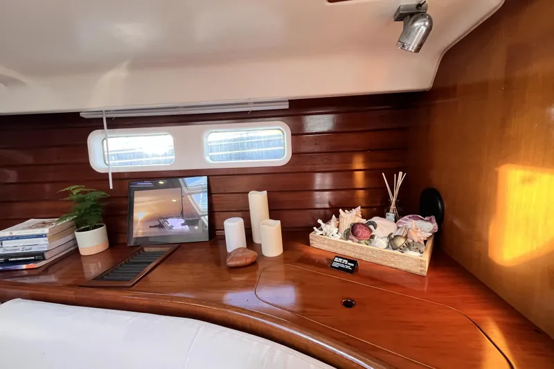 Windnsea Yacht Photos Pics Interior of 2001 Beneteau 473 yacht with decor, books, and seashells on wooden surface.