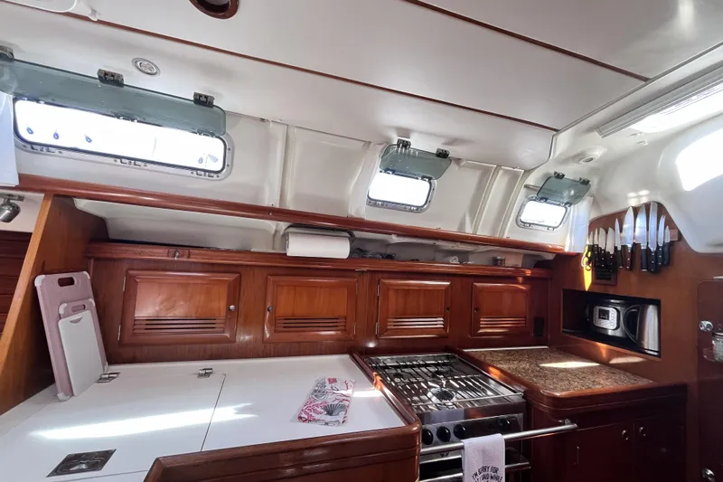 Windnsea Yacht Photos Pics Interior of 2001 Beneteau 473 yacht kitchen with wooden cabinets and modern appliances.