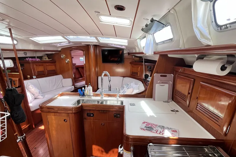 Windnsea Yacht Photos Pics Luxurious interior of a 2001 Beneteau 473 sailboat with wood finishes and modern amenities.