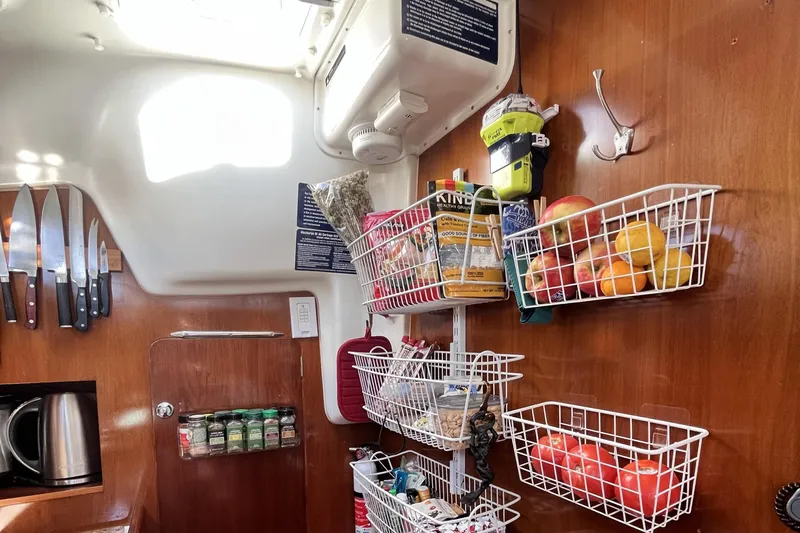 Windnsea Yacht Photos Pics Interior of a 2001 Beneteau 473 sailboat galley with organized storage baskets and knives.