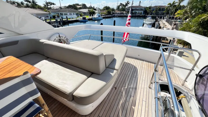Sea Sea Elle Yacht Photos Pics Luxurious 2019 Princess F62 yacht deck with seating, docked in a scenic marina.