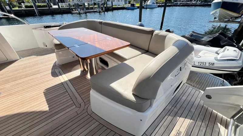 Sea Sea Elle Yacht Photos Pics Luxurious seating area on 2019 Princess F62 yacht with wooden table, docked at marina.