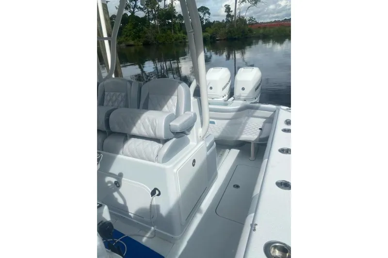 Lauren J Yacht Photos Pics 2022 Yellowfin 32 boat interior with seating and dual engines on a calm water backdrop.