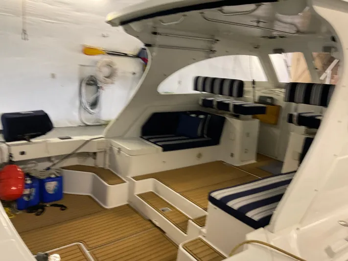  Yacht Photos Pics Interior of 2000 Mainship Pilot boat with striped seating and wooden flooring.
