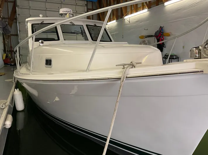  Yacht Photos Pics 2000 Mainship Pilot boat docked indoors, showcasing sleek white hull and cabin.