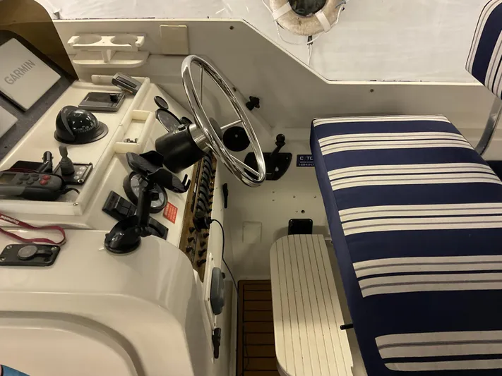  Yacht Photos Pics 2000 Mainship Pilot boat helm with striped seating and navigation equipment.