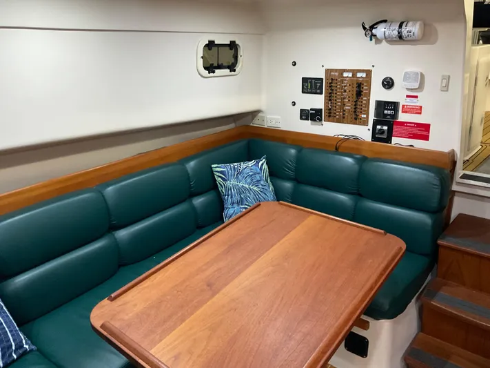  Yacht Photos Pics 2000 Mainship Pilot interior with green seating, wooden table, and control panel.