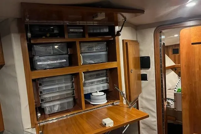 Steamer Yacht Photos Pics Interior storage of 2008 Albemarle 410 Express Fisherman with organized compartments and wooden finish.