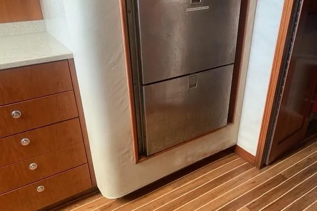 Steamer Yacht Photos Pics 2008 Albemarle 410 Express Fisherman interior with stainless steel fridge and wooden cabinetry.