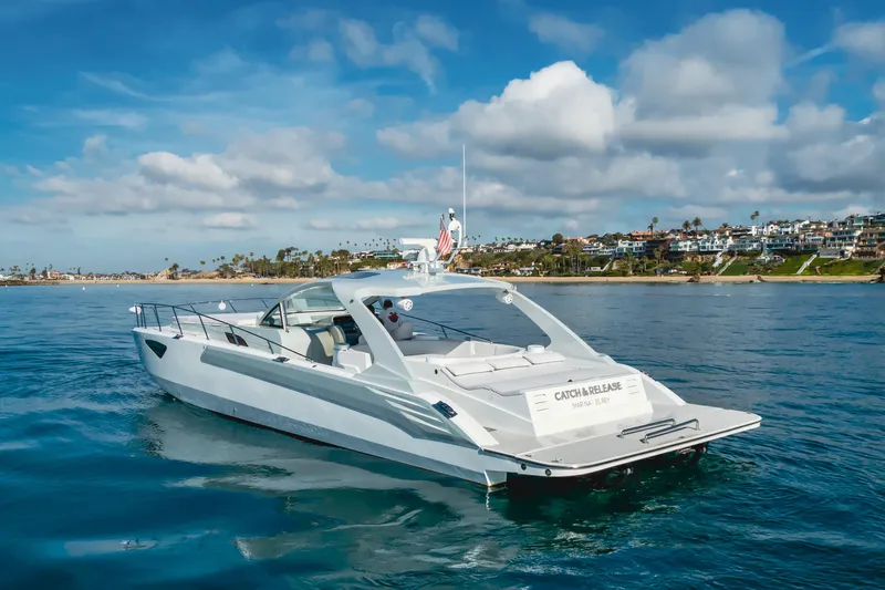 Catch & Release Yacht Photos Pics Luxurious 2017 Custom 60 yacht cruising near scenic coastal homes under a partly cloudy sky.