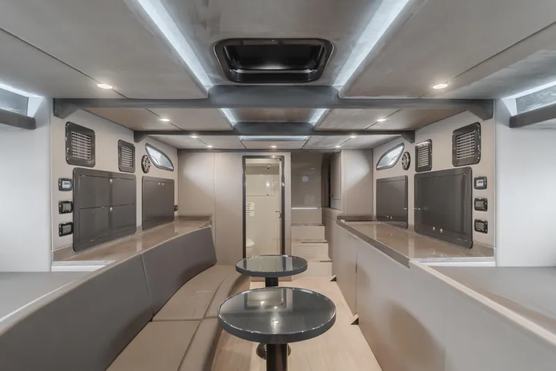 Catch & Release Yacht Photos Pics Modern interior of a 2017 Custom 60 yacht with sleek seating and tables.