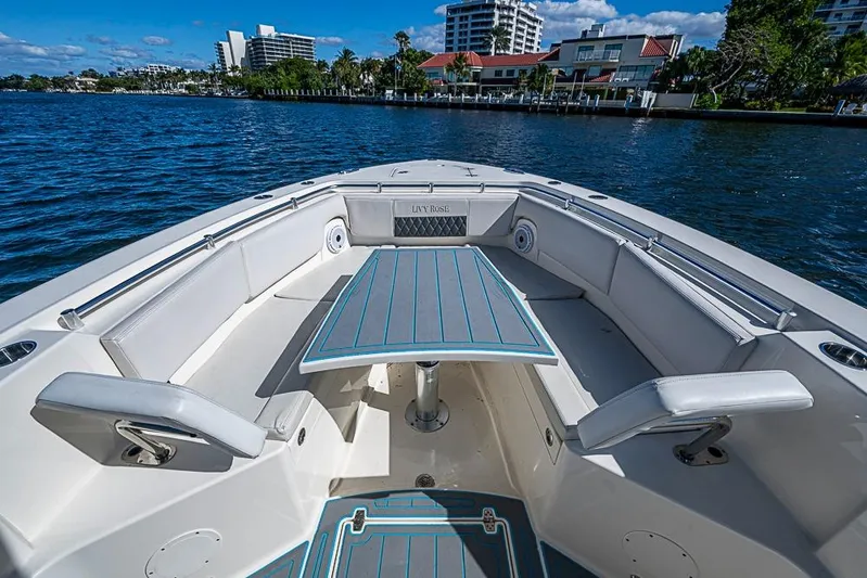 Livy Rose Yacht Photos Pics 2021 Cobia 320 Center Console boat interior with seating and table on calm water.