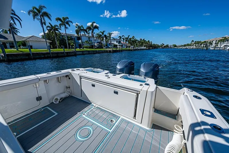 Livy Rose Yacht Photos Pics 2021 Cobia 320 Center Console boat on a sunny waterfront with palm trees.
