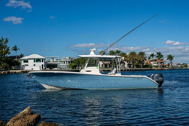 Livy Rose Yacht Photos Pics 2021 Cobia 320 Center Console boat on calm water, with luxury homes in the background.