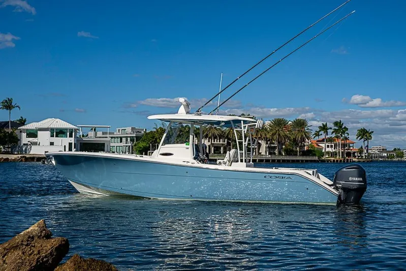 Livy Rose Yacht Photos Pics 2021 Cobia 320 Center Console boat on water, with coastal homes in the background.