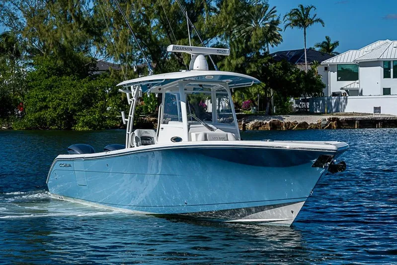 Livy Rose Yacht Photos Pics 2021 Cobia 320 Center Console boat cruising on a sunny day near waterfront homes.