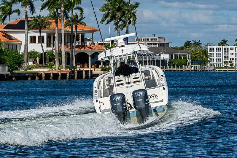 Livy Rose Yacht Photos Pics 2021 Cobia 320 Center Console boat cruising on a sunny waterfront with luxury homes.