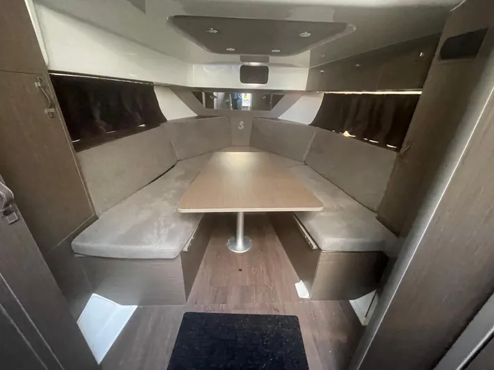  Yacht Photos Pics 2024 Beneteau Gran Turismo 32 interior with cozy seating and central table.