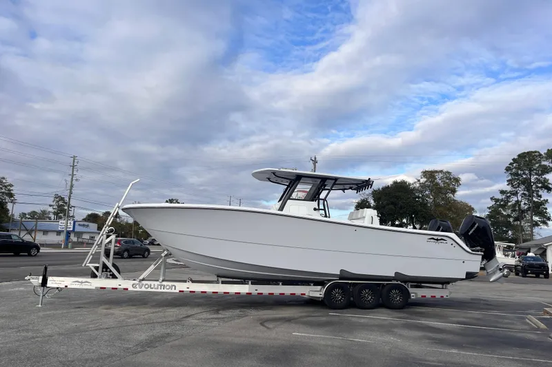  Yacht Photos Pics 2026 Invincible 33 Catamaran on trailer, parked outdoors under cloudy sky.