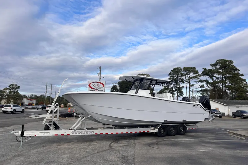  Yacht Photos Pics 2026 Invincible 33 Catamaran on trailer at dealership, under cloudy sky.