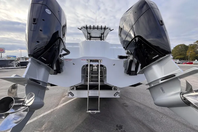  Yacht Photos Pics 2026 Invincible 33 Catamaran with dual outboard engines, rear view in a parking lot.