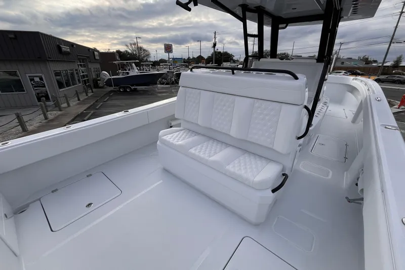  Yacht Photos Pics 2026 Invincible 33 Catamaran with white seating, docked at a marina under cloudy skies.