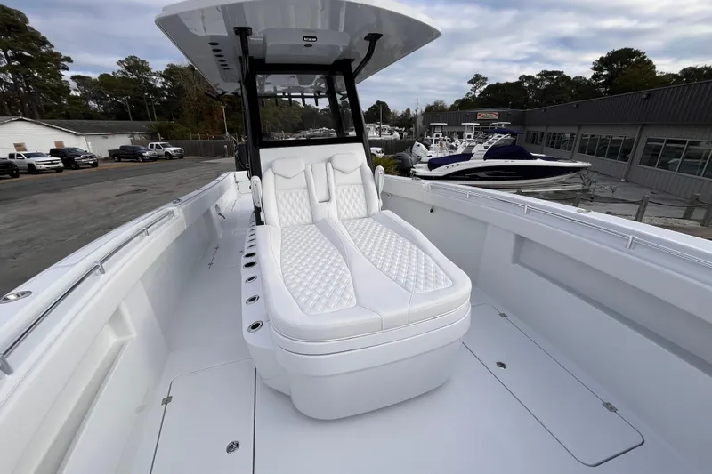  Yacht Photos Pics 2026 Invincible 33 Catamaran with luxurious white seating, docked at a marina.