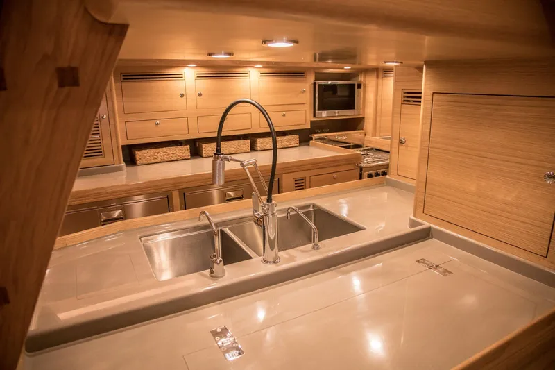 Pneumatic Yacht Photos Pics Luxurious kitchen interior of 2020 Outbound 56 yacht with modern fixtures and wooden cabinetry.