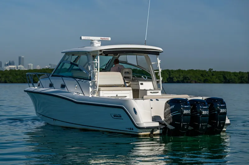  Yacht Photos Pics 2017 Boston Whaler 345 Conquest boat with triple Mercury engines on calm water.