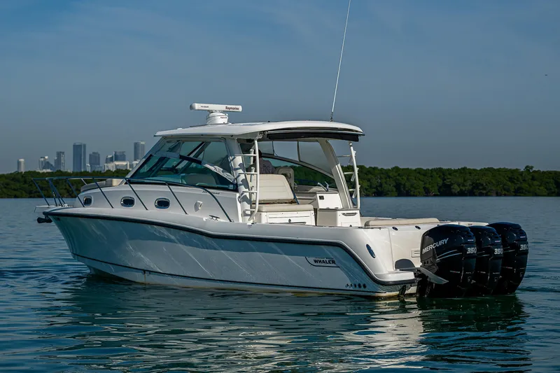  Yacht Photos Pics 2017 Boston Whaler 345 Conquest boat on calm water with city skyline in background.