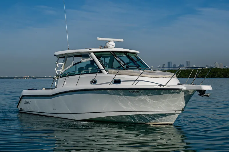  Yacht Photos Pics 2017 Boston Whaler 345 Conquest boat on calm water with city skyline.