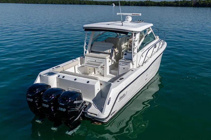  Yacht Photos Pics 2017 Boston Whaler 345 Conquest boat with triple Mercury engines on calm water.