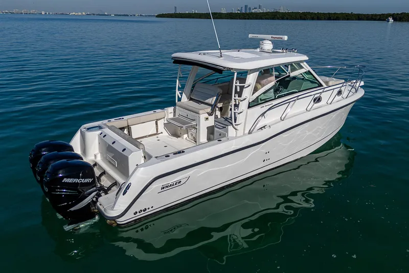  Yacht Photos Pics 2017 Boston Whaler 345 Conquest boat on calm water, featuring triple Mercury engines.