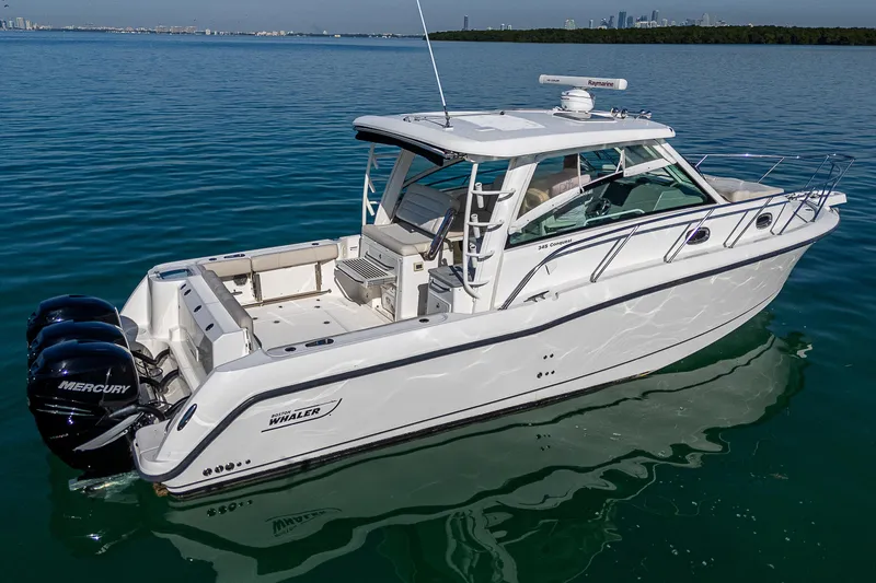  Yacht Photos Pics 2017 Boston Whaler 345 Conquest boat on calm water, featuring triple Mercury engines.