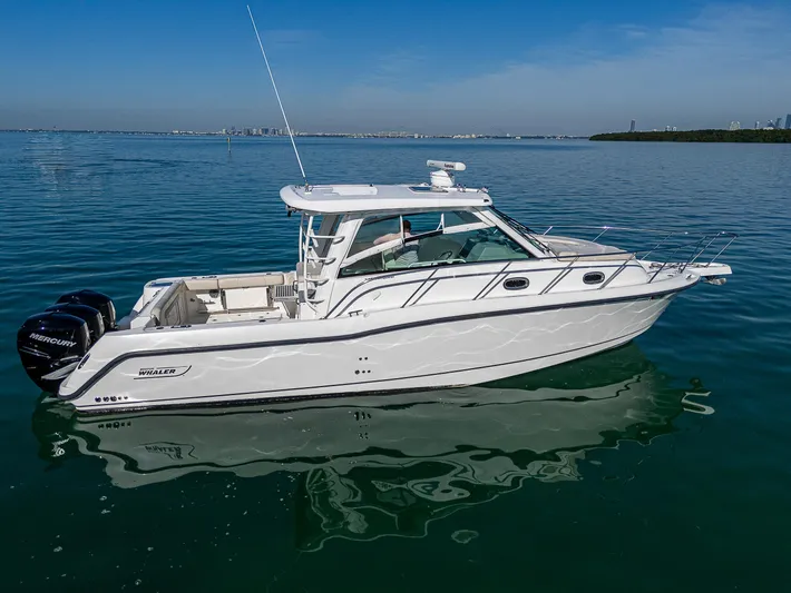  Yacht Photos Pics 2017 Boston Whaler 345 Conquest boat on calm water under clear blue sky.
